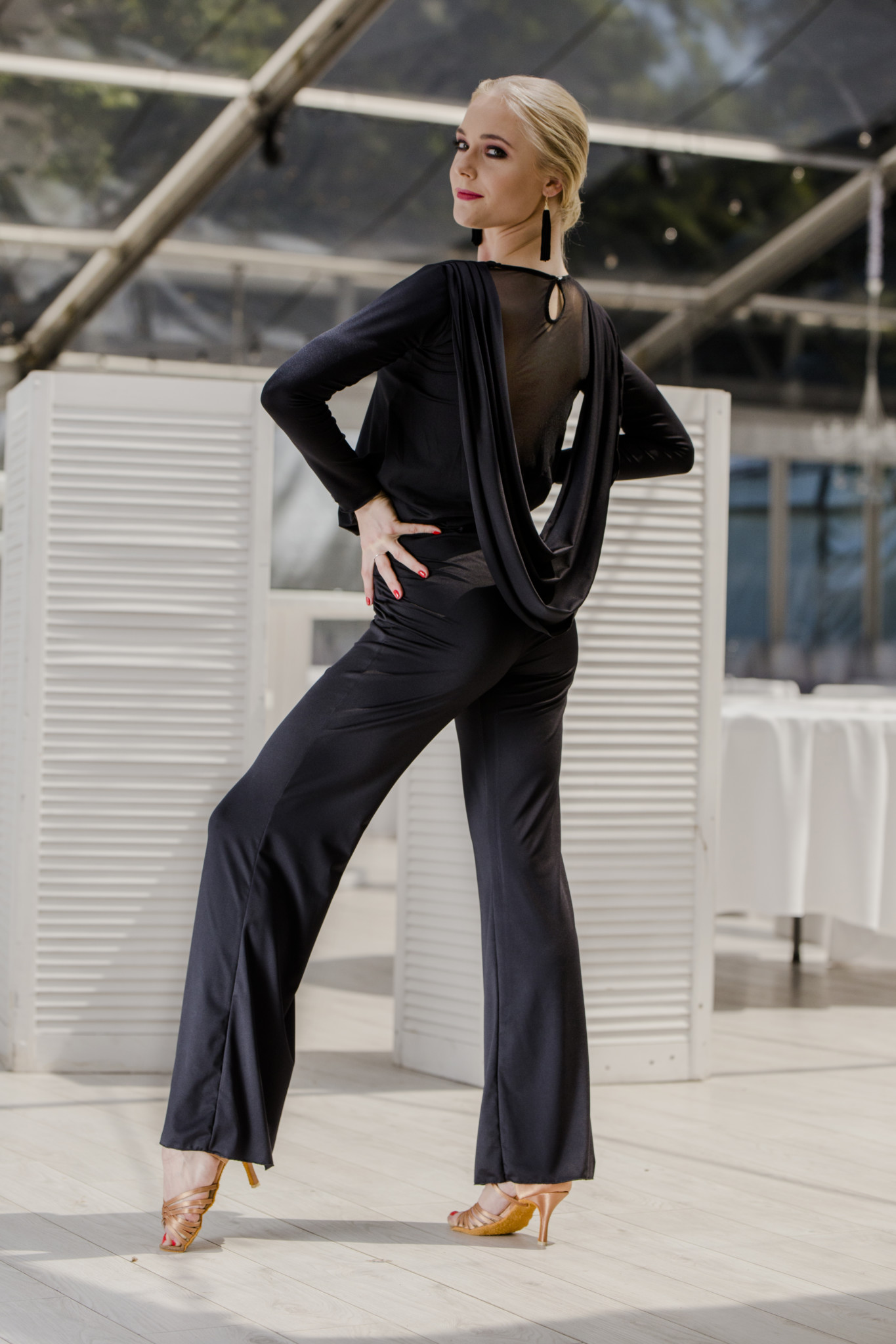 Model showcasing elegant black dance jumpsuit with stylish back detail.