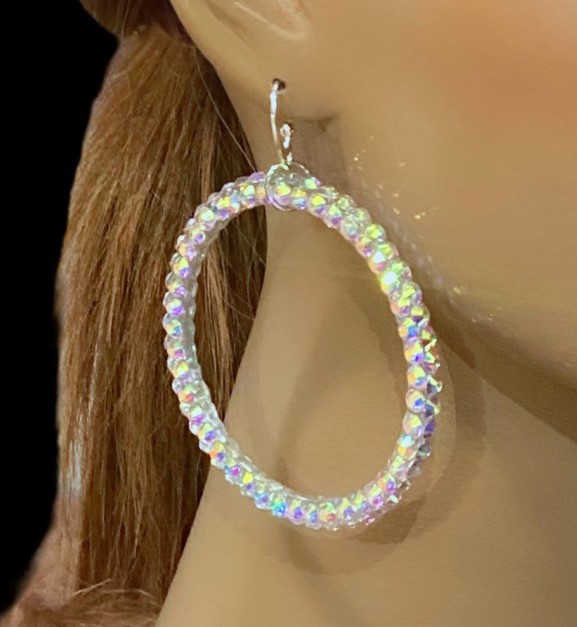 Iridescent hoop earring worn by a mannequin