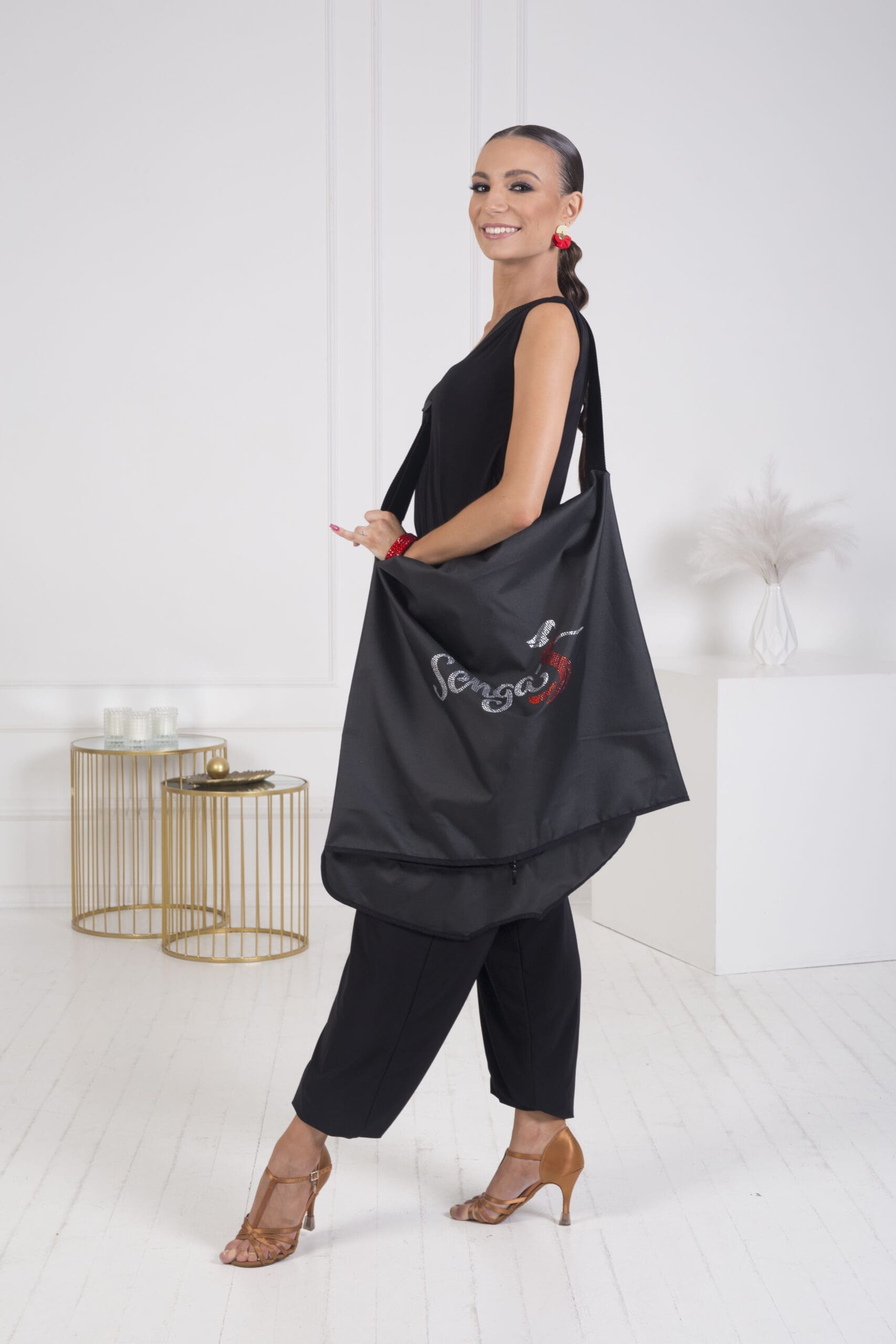 Model showcasing a stylish black dance bag with the Senga logo.